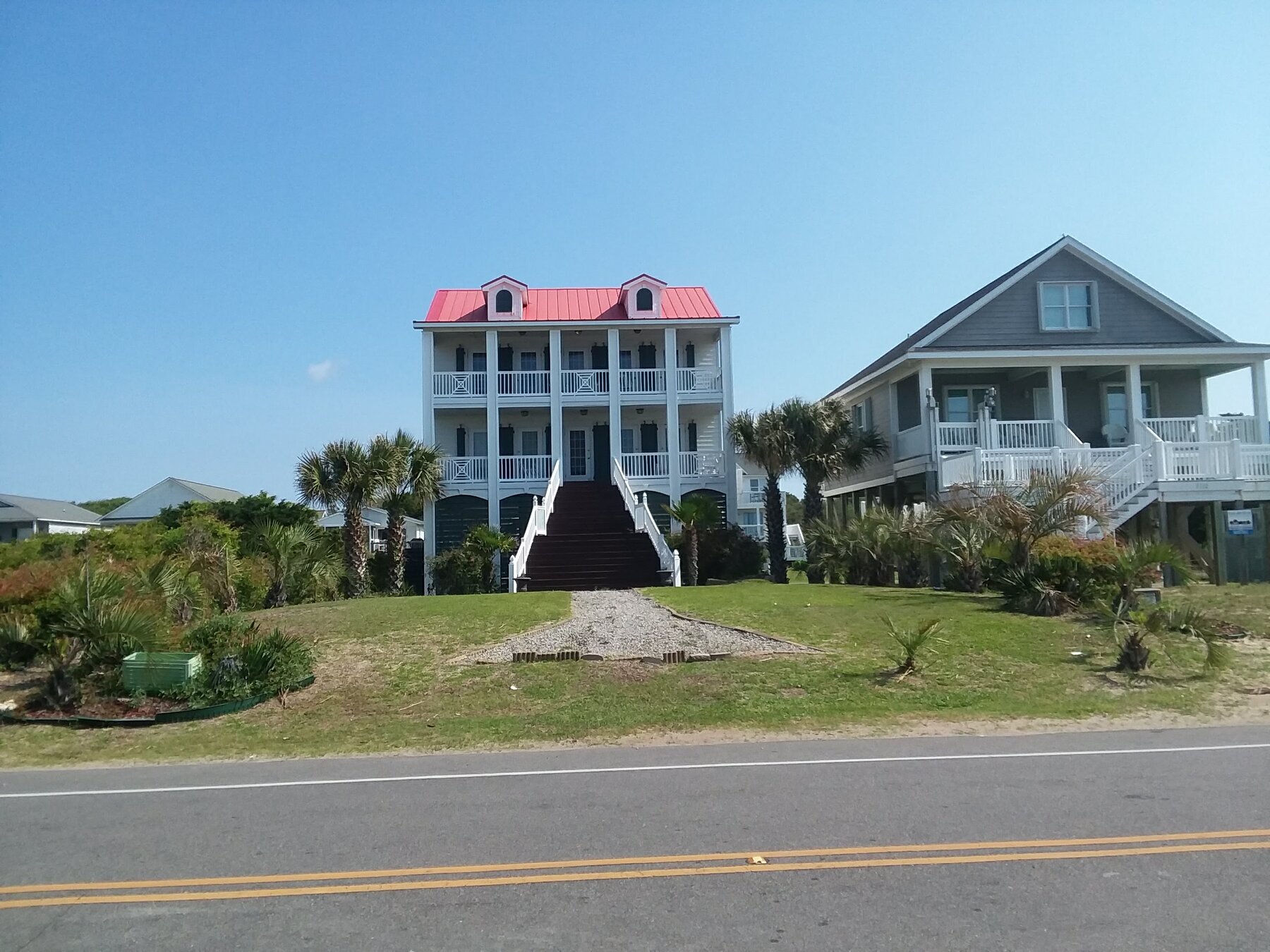 3-story coastal house with red metal roof