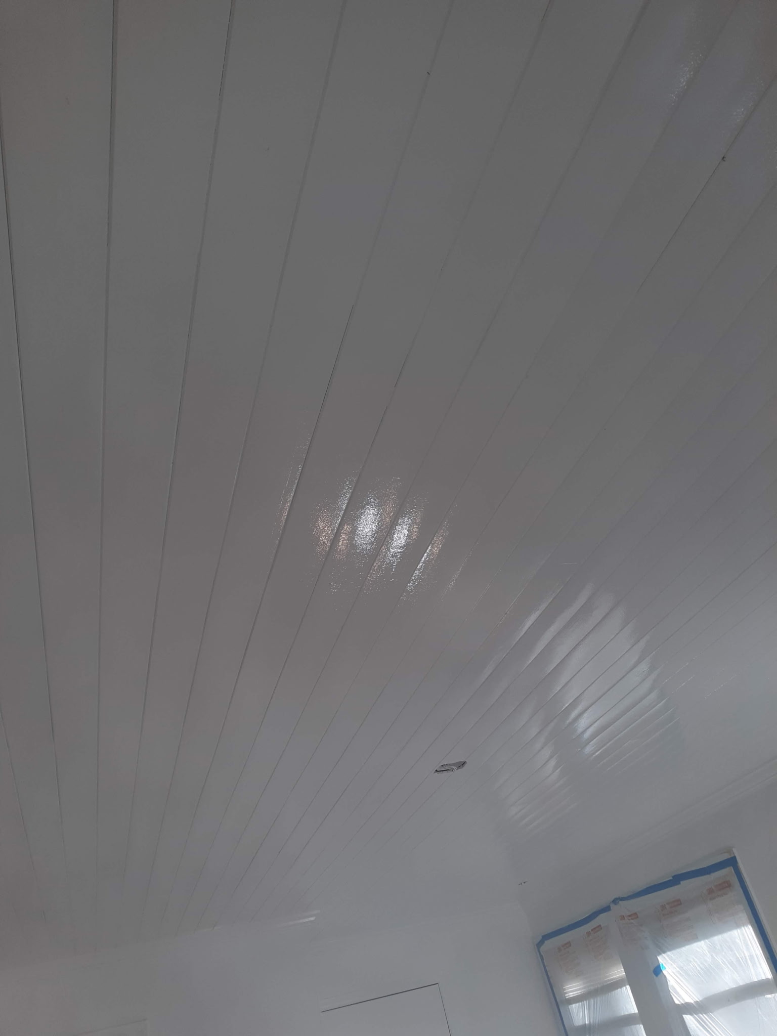 Glossy white tongue-and-groove ceiling installed and painted by Flying Colors