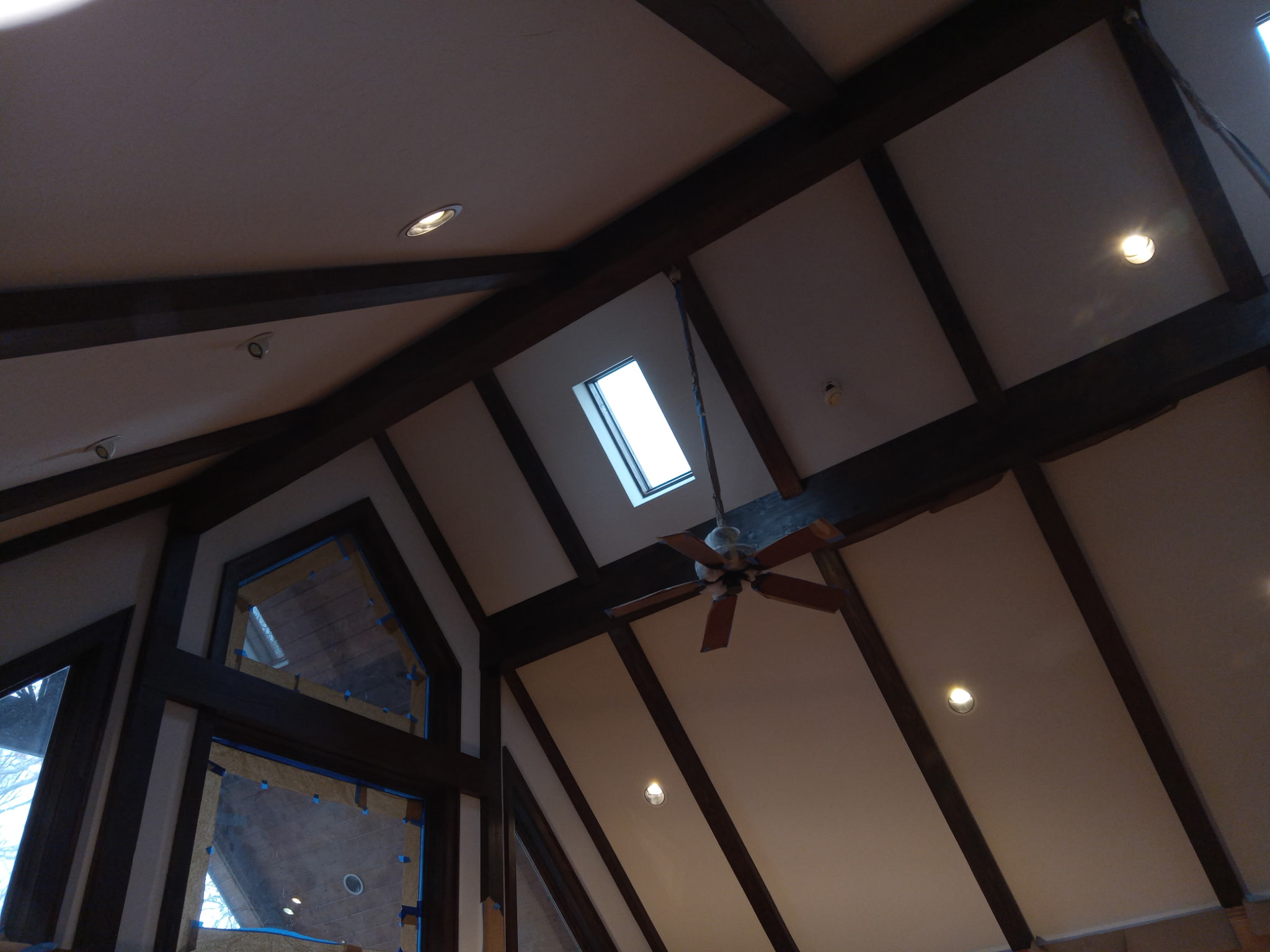 Vaulted ceiling with dark wood beams and cream painted panels